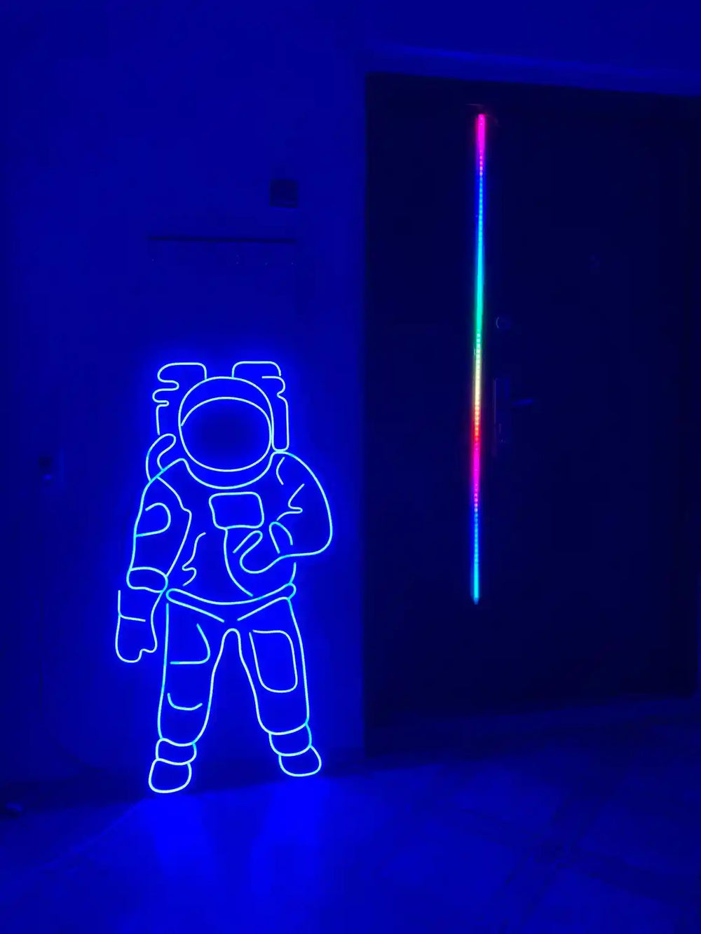 Blue colored Astronaut LED Neon Sign placed on the floor beside a door - from manhattonneons.com.